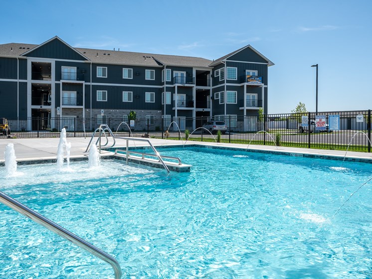 A swimming pool in front of a multi-story building.